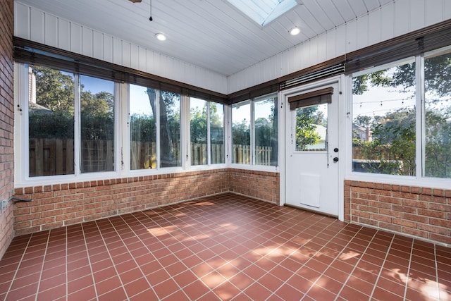 unfurnished sunroom featuring a skylight