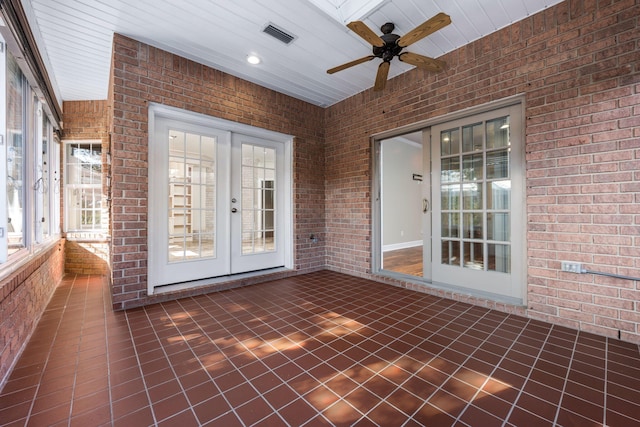 unfurnished sunroom featuring visible vents, a ceiling fan, and french doors