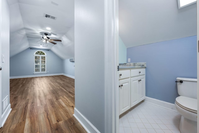 half bathroom featuring visible vents, toilet, baseboards, and vaulted ceiling