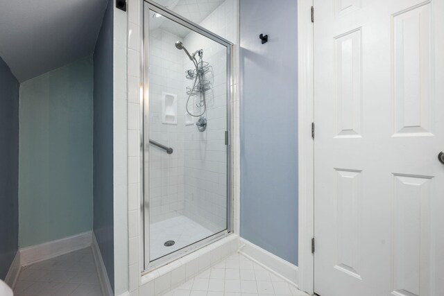 bathroom with tile patterned flooring, a stall shower, and baseboards