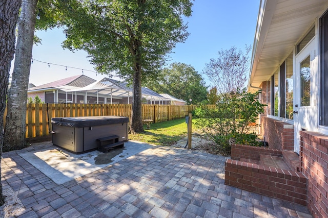 view of patio / terrace featuring a hot tub and a fenced backyard