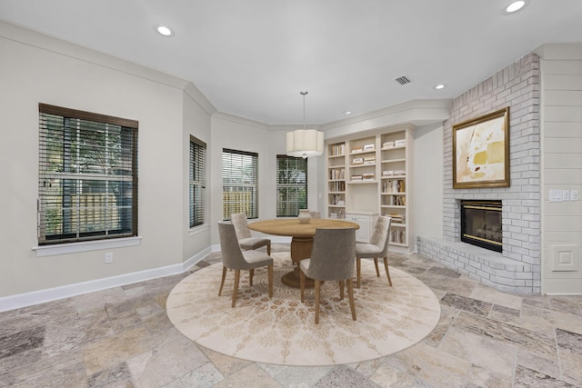 dining area with stone tile floors, baseboards, visible vents, recessed lighting, and a brick fireplace