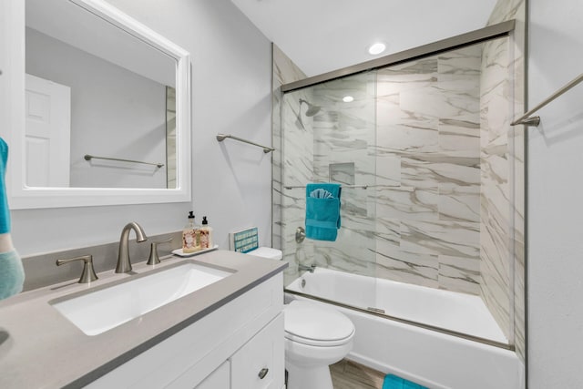 full bathroom with vanity, toilet, shower / bath combination with glass door, and wood-type flooring