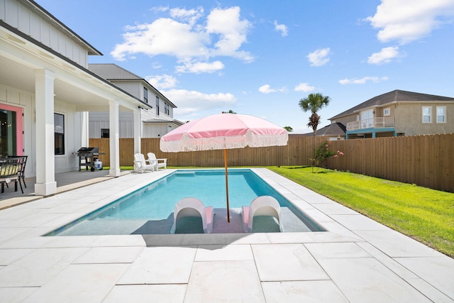 view of swimming pool featuring a grill, a patio area, and a lawn