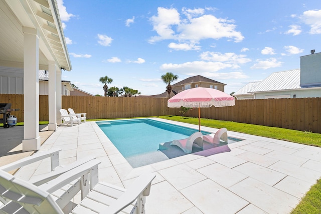 view of pool with a patio area and a lawn