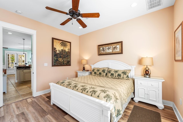 bedroom with ceiling fan and hardwood / wood-style flooring