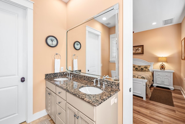 bathroom featuring vanity, wood-type flooring, and toilet