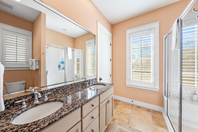 bathroom with vanity, a shower with shower door, and toilet