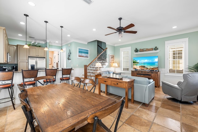 dining space featuring ceiling fan and ornamental molding