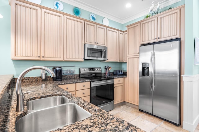 kitchen with stainless steel appliances, crown molding, dark stone countertops, and sink