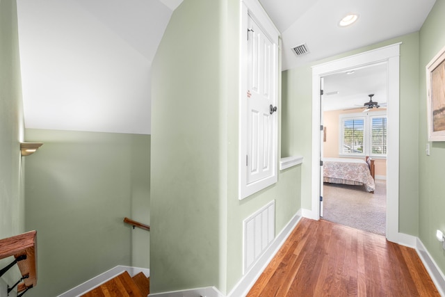 corridor featuring hardwood / wood-style floors and vaulted ceiling