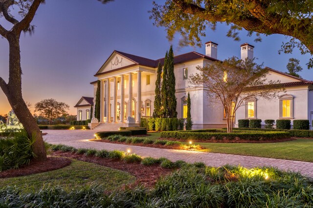 greek revival house with a lawn