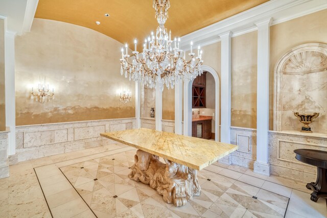 tiled dining area featuring decorative columns, an inviting chandelier, lofted ceiling, and ornamental molding