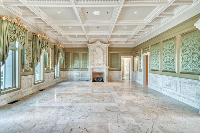 unfurnished living room featuring beamed ceiling, coffered ceiling, and a premium fireplace