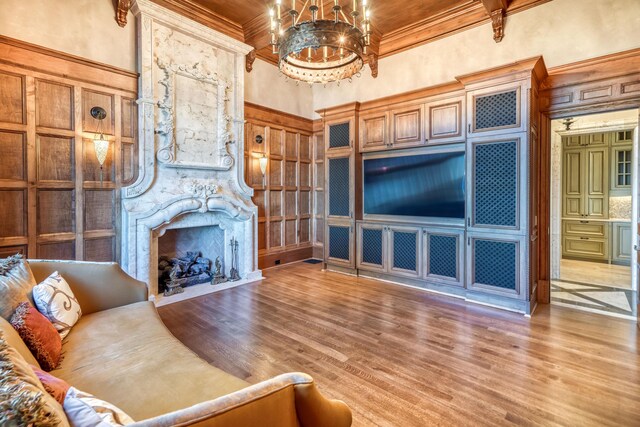 living room featuring wood-type flooring, crown molding, a high ceiling, and a chandelier