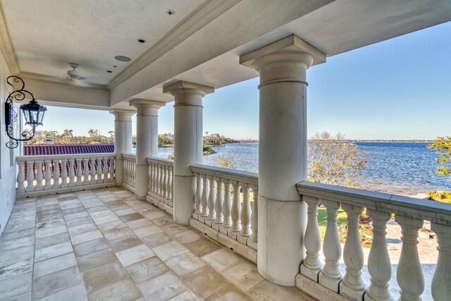 balcony with ceiling fan and a water view