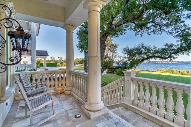 view of patio with covered porch and a water view