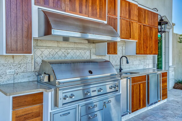 kitchen with stainless steel fridge, exhaust hood, backsplash, and sink