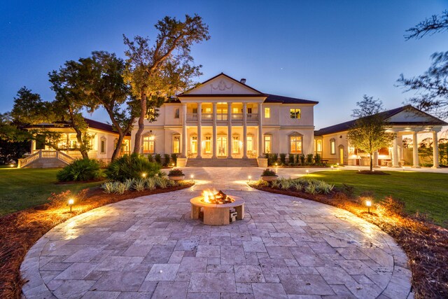 view of front of house featuring an outdoor fire pit, a patio area, and a lawn