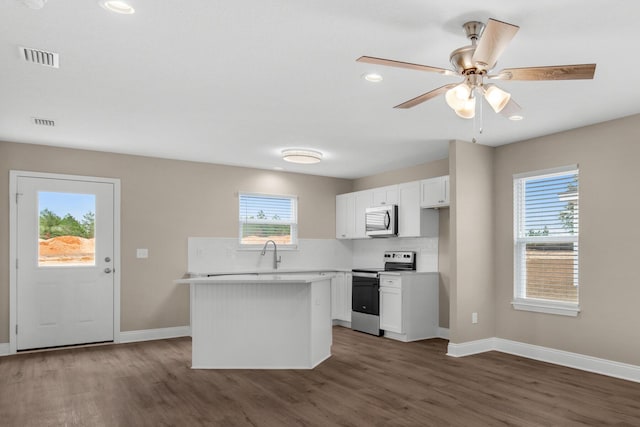 kitchen with white cabinetry, dark hardwood / wood-style flooring, a center island, and stainless steel appliances