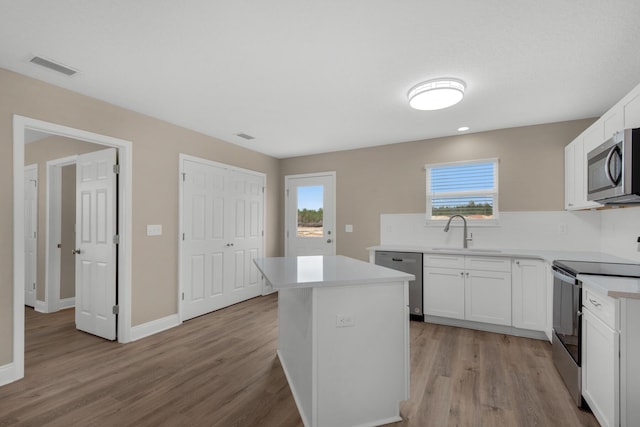 kitchen with white cabinets, appliances with stainless steel finishes, plenty of natural light, and sink