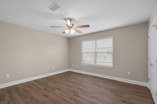 empty room featuring a textured ceiling and dark wood-type flooring