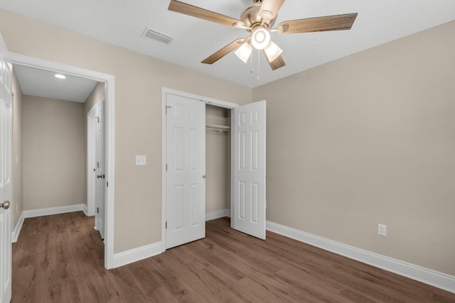 unfurnished bedroom with ceiling fan, a closet, and wood-type flooring