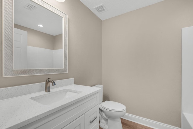 bathroom featuring wood-type flooring, vanity, and toilet