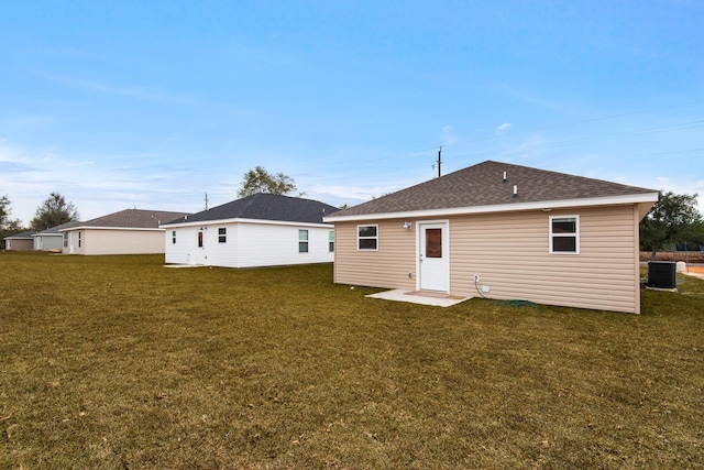 rear view of house with a yard and central AC unit