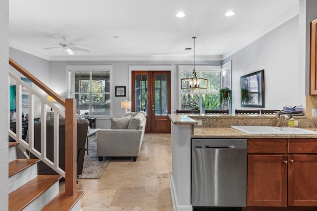 kitchen featuring dishwasher, ceiling fan with notable chandelier, sink, hanging light fixtures, and light stone counters