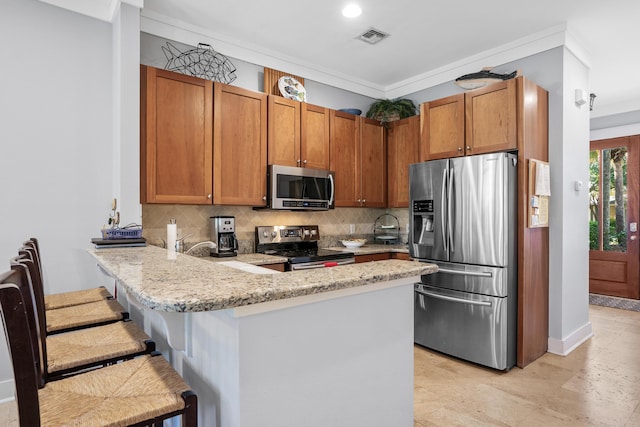 kitchen featuring a breakfast bar, kitchen peninsula, backsplash, and appliances with stainless steel finishes