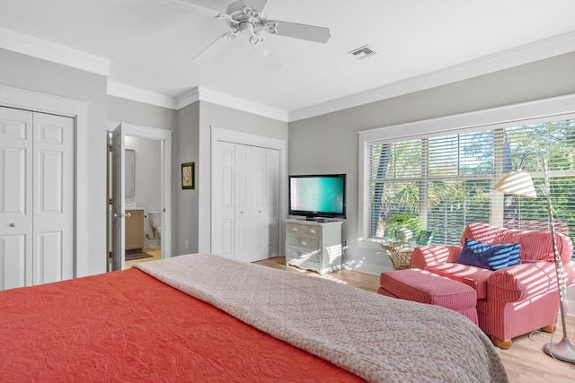 bedroom with multiple closets, light wood-type flooring, ceiling fan, and ornamental molding