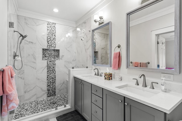 bathroom featuring a tile shower, vanity, and ornamental molding