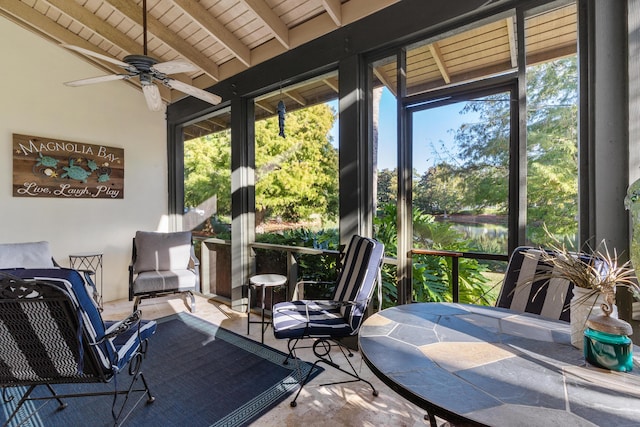 sunroom featuring vaulted ceiling with beams, plenty of natural light, wooden ceiling, and ceiling fan