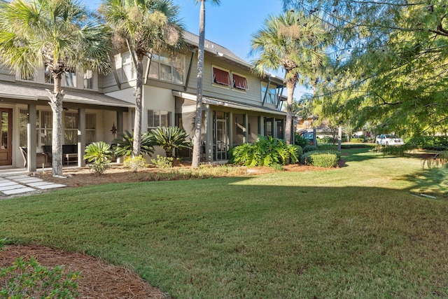 rear view of house featuring a sunroom and a yard