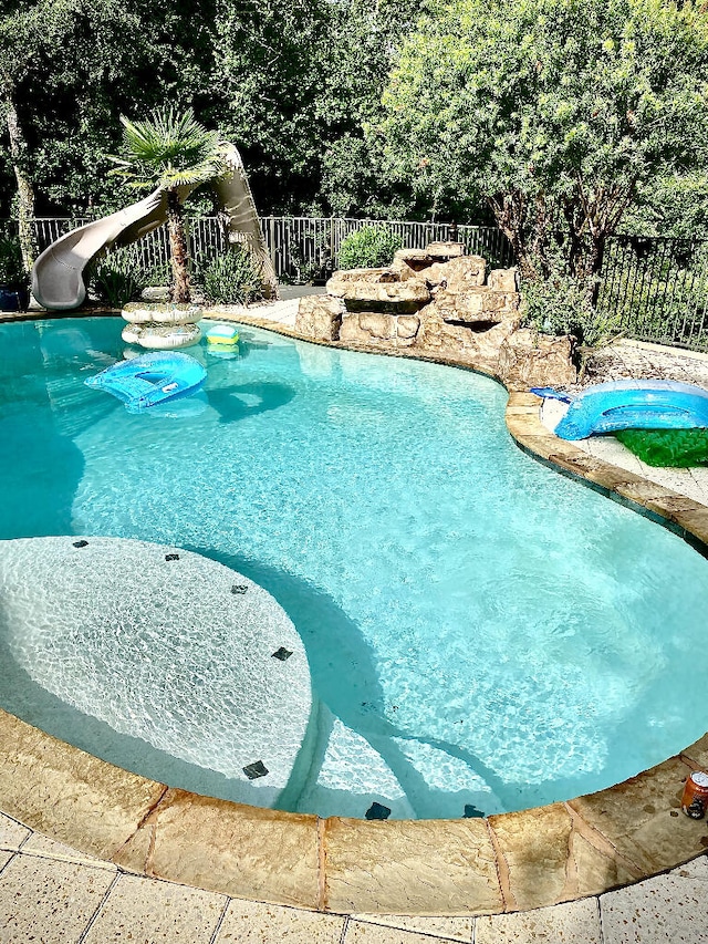 view of swimming pool with a water slide