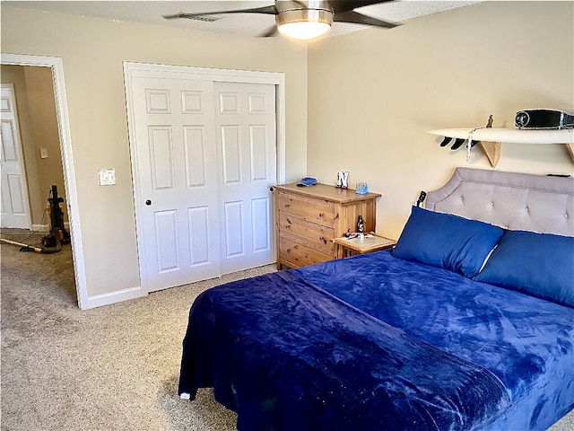 carpeted bedroom featuring ceiling fan and a closet