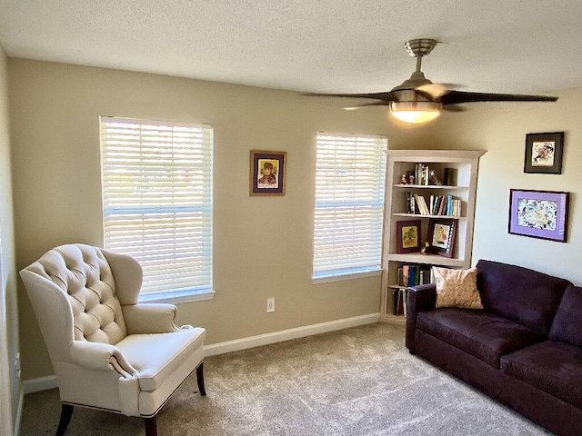 sitting room featuring light carpet, ceiling fan, a wealth of natural light, and a textured ceiling