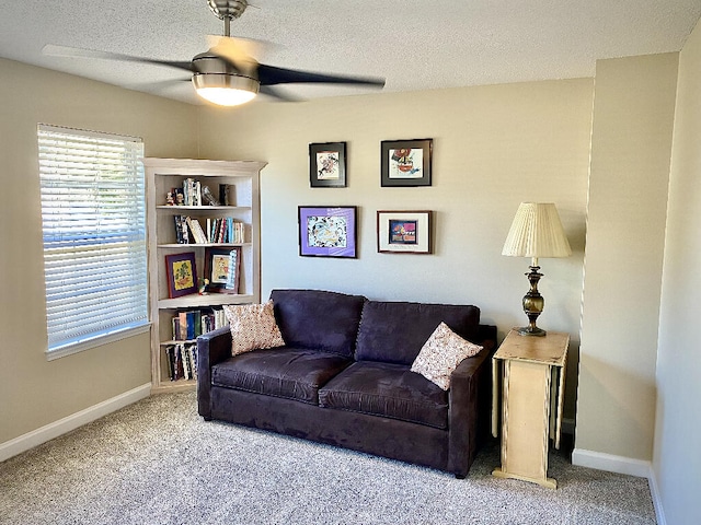 living room with ceiling fan, carpet, and a textured ceiling