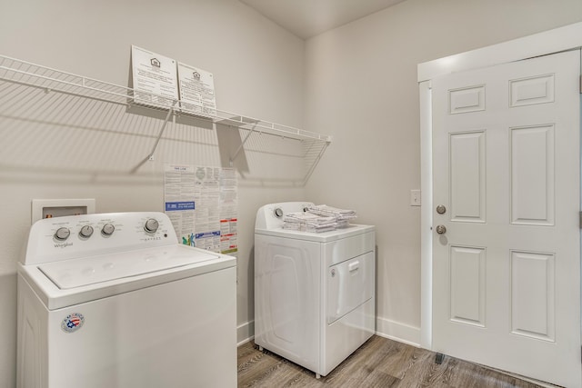 clothes washing area with hardwood / wood-style flooring and separate washer and dryer