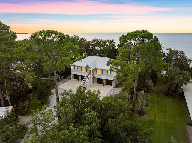 aerial view at dusk featuring a water view