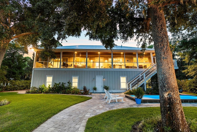 view of front of house featuring a patio area, a balcony, and a front yard