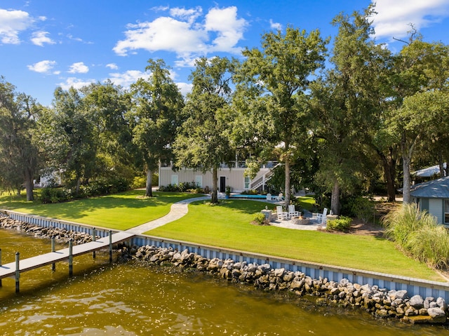 view of dock with a water view and a yard