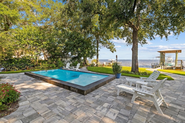 view of pool with a patio area and a water view