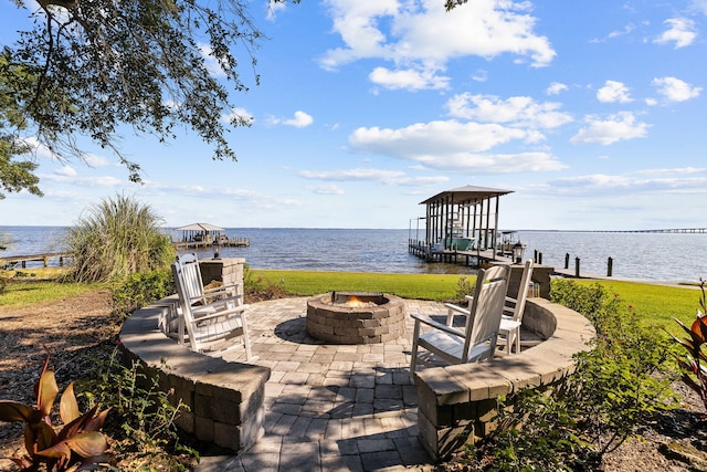 view of patio featuring a boat dock, a water view, and an outdoor fire pit