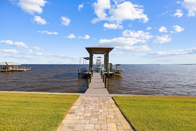 dock area featuring a lawn and a water view