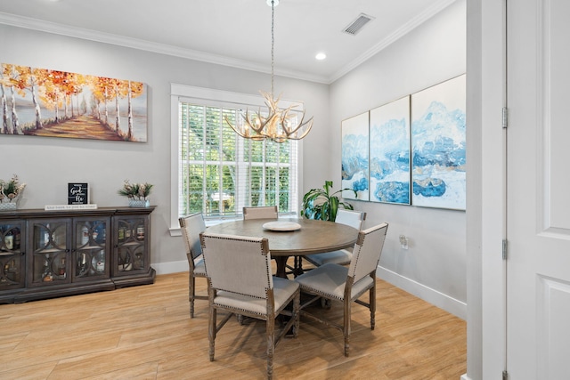 dining space featuring light wood-type flooring, crown molding, and a chandelier