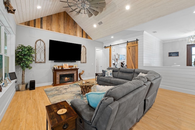 living room with a barn door, a healthy amount of sunlight, and light wood-type flooring