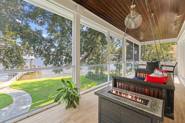 sunroom featuring a water view and wooden ceiling