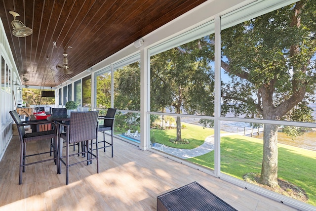 unfurnished sunroom with ceiling fan and wooden ceiling